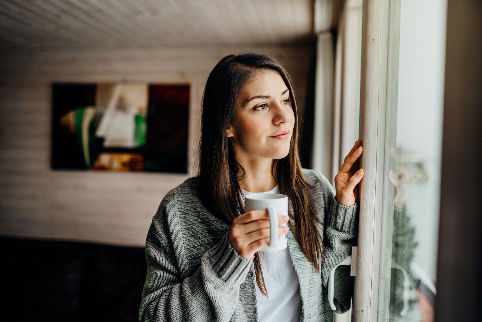 Mujer mira por la ventana durante el distanciamiento social